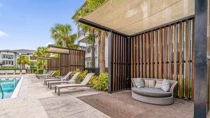 Ein Poolbereich mit Liegestühlen, einer Sitzecke und einer Pergola.