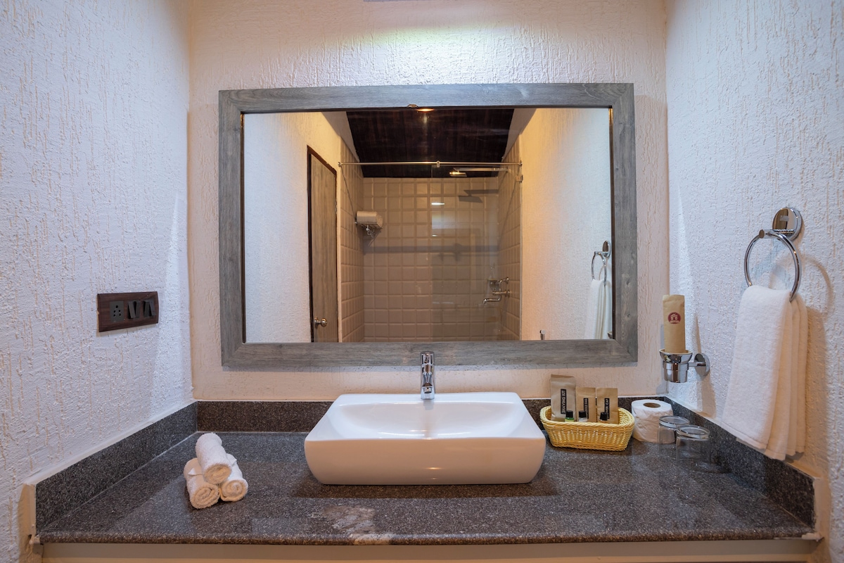Een badkamer met een grote spiegel, een wastafel en een douche.