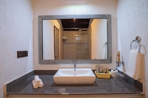 Een badkamer met een grote spiegel, een wastafel en een douche.