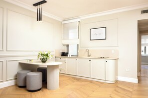 A modern kitchen with a central island, pendant lighting, and a framed quote on the wall. - Vucino Suites (Istanbul)