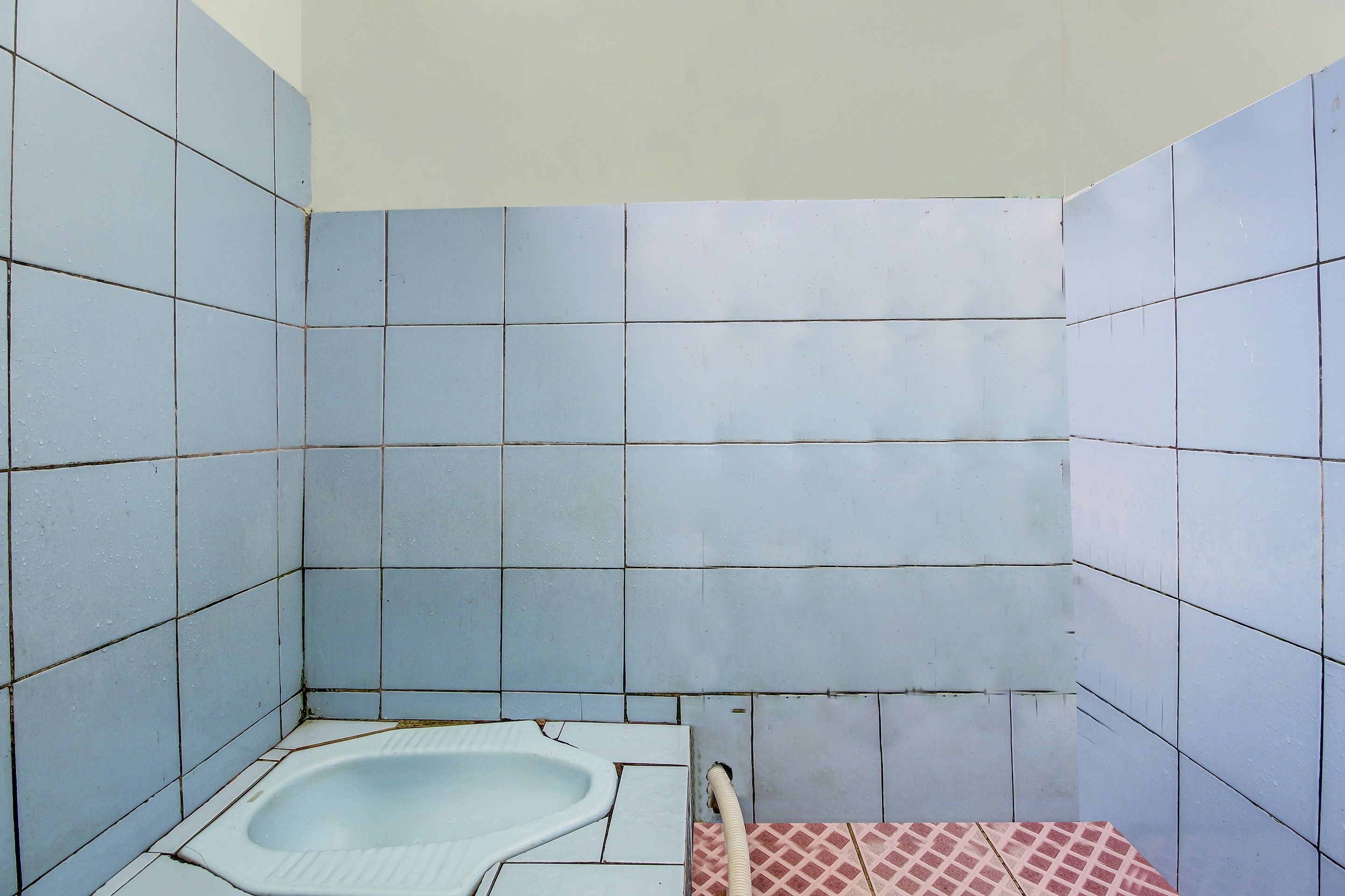 A small, tiled bathroom with a single bathtub and a shower area.