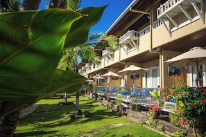 A hotel with multiple balconies, outdoor seating, and a well-maintained garden. - Tauch Terminal Resort Tulamben & Spa (Rendang)