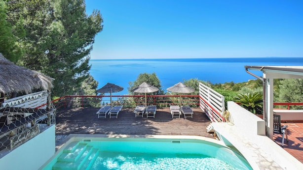 A pool area with lounge chairs and umbrellas, overlooking a body of water. - Beautiful home in Sperlonga (Sperlonga)