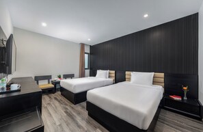 A modern hotel room with two beds, a desk, and a small seating area. - Alcove Da Nang Bay Boutique Hotel (Da Nang Municipality)
