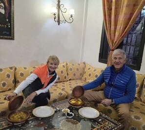 Ein Wohnzimmer mit einer Couch, einem Tisch mit Geschirr und einer Chandelier.