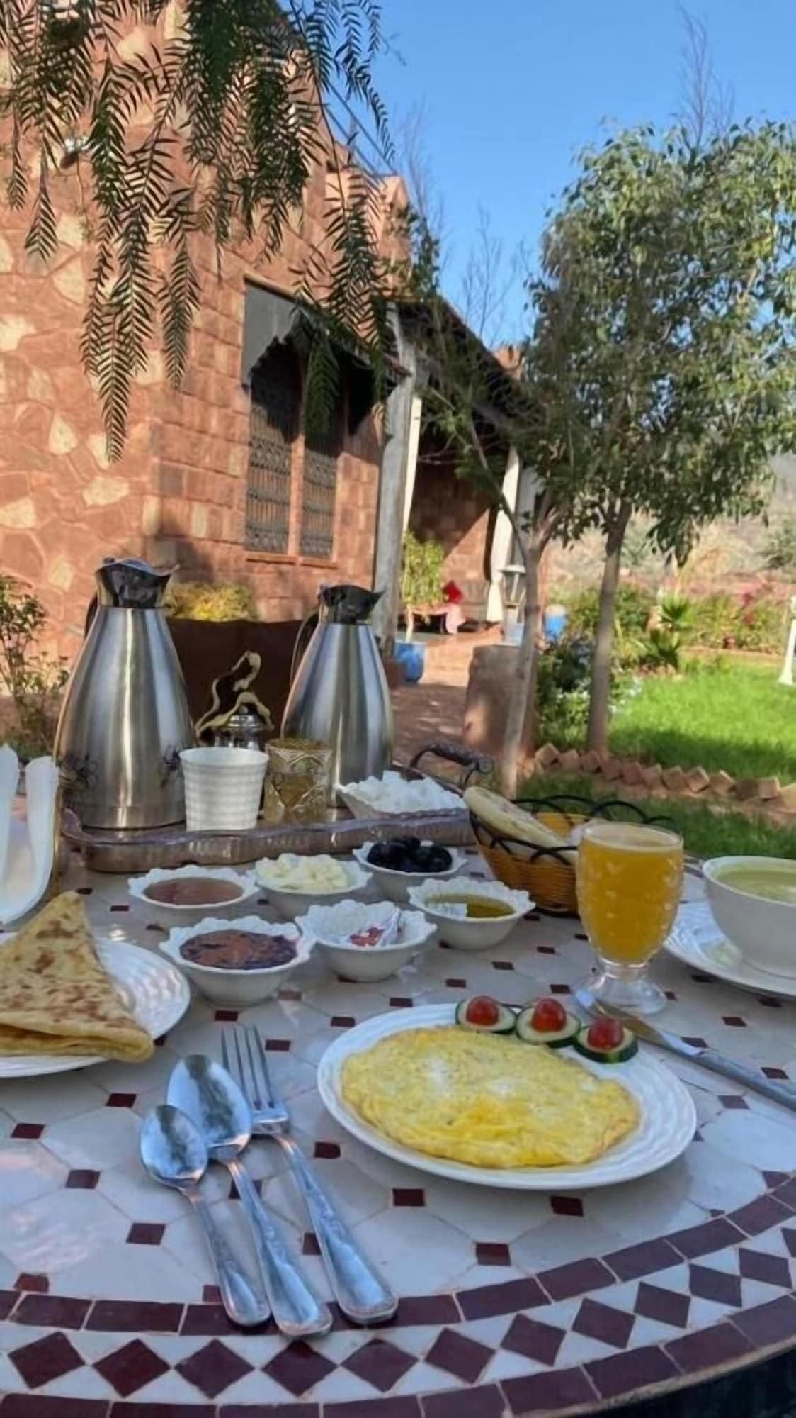 An outdoor dining setup with a variety of dishes, including flatbreads, a plate of eggs, and fruit.