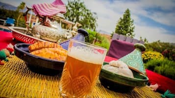 A table with a glass of beer, a bowl of food, and traditional Moroccan pottery.
