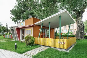 Un edificio moderno con un espacio exterior cubierto, una valla de madera y un letrero que dice 'Astro'.