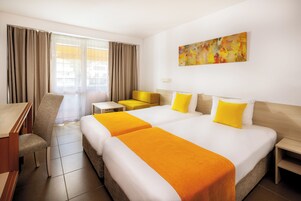 Una habitación de hotel con una cama grande, un sofá, un escritorio y una silla.