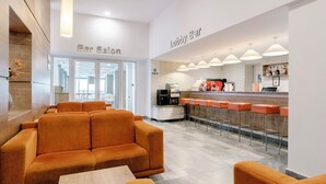 A lobby with a sofa, a bar area, and a bar salon. - Aluasun Helios Beach (Nessebar)