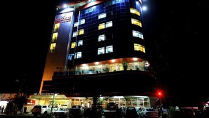 A multi-story hotel with illuminated windows and a sign indicating it is a hotel.