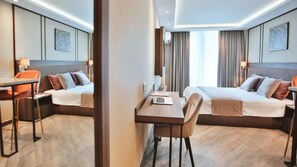 Une chambre d’hôtel avec deux lits, un bureau et une chaise.