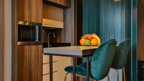 Een moderne keuken met een ingebouwde magnetron, een spoelbak en een fruitschaal op het aanrecht.