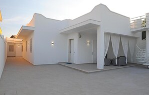 Ein modernes, weißes Gebäude mit überdachter Außenbereich und einer Treppe.