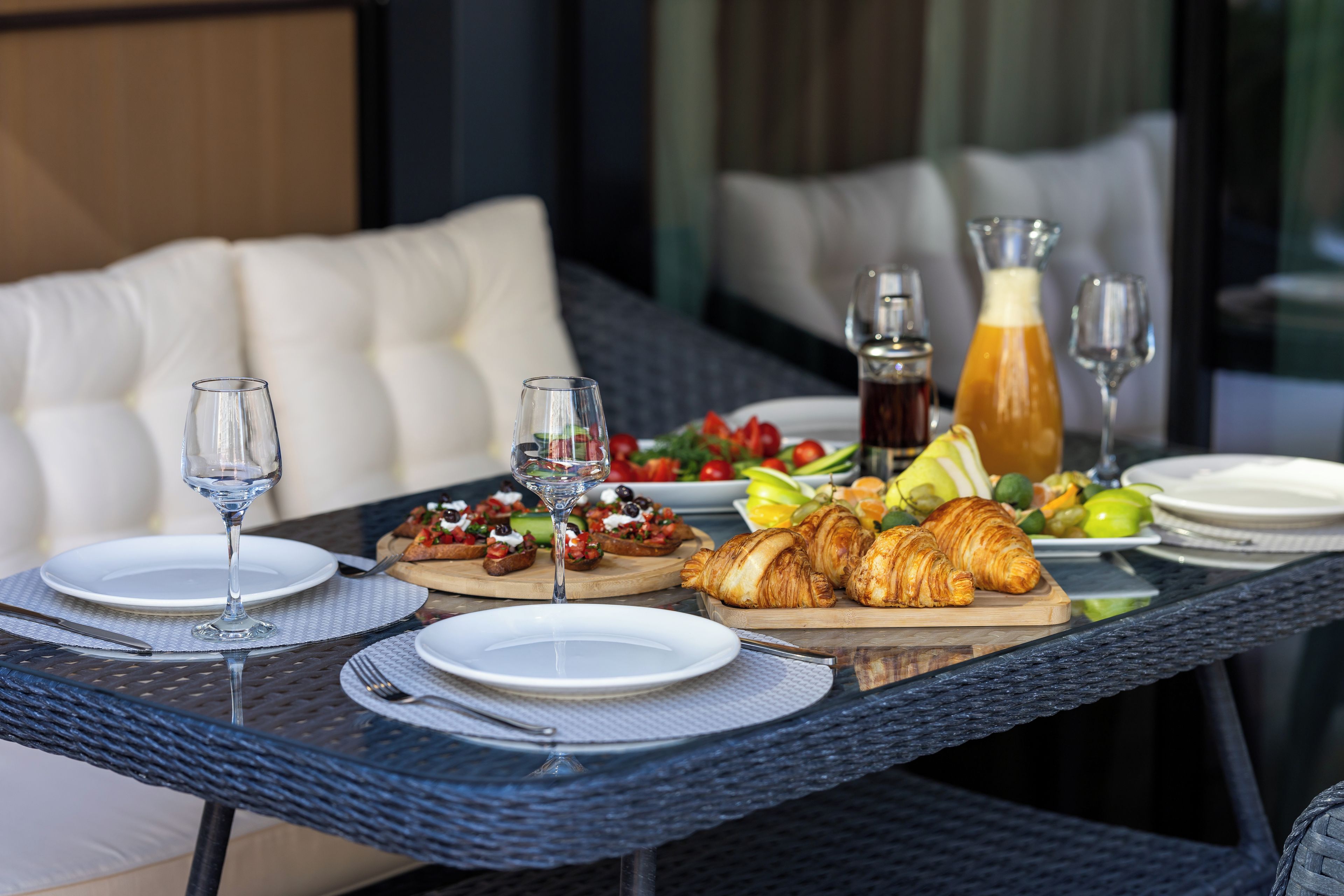 A dining table with plates, cutlery, glasses, and food items.