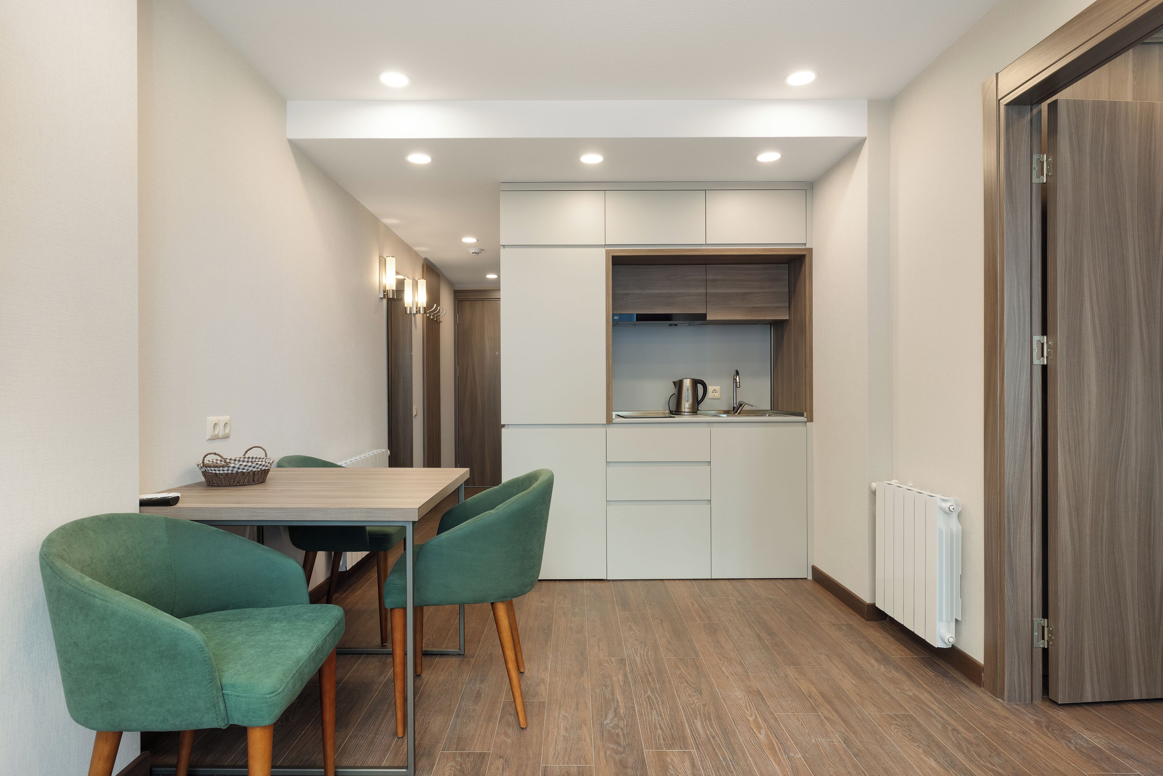 Una cocina moderna con zona de comedor, que incluye una mesa y sillas, y un horno empotrado.