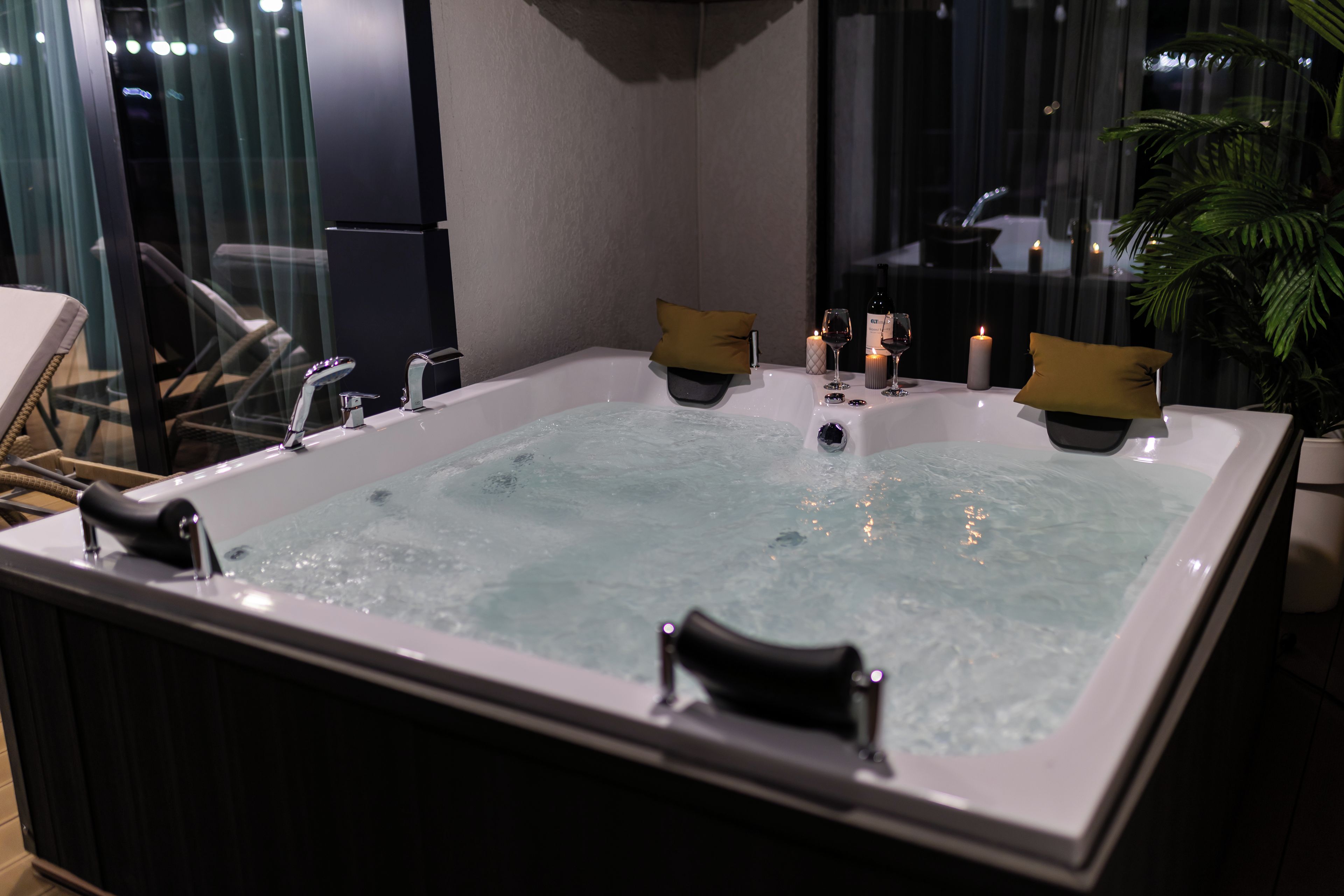 A hot tub with a view of the city at night.