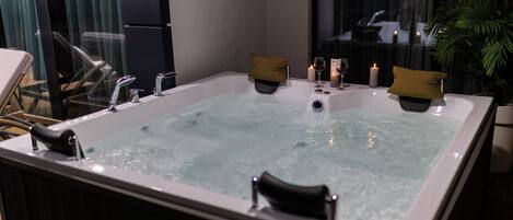 A hot tub with a view of the city at night.