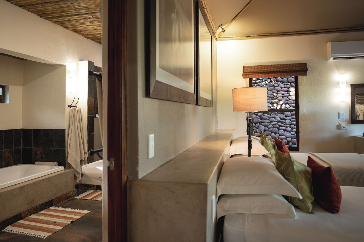 A bathroom with a bathtub, a towel rack, and a mirror.