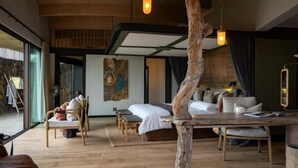 Un dormitorio moderno con una cama grande, muebles de madera y vistas a través de un ventanal.