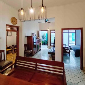 A spacious living area with a wooden bench, a clock, and a ceiling fan. - Serene 2-bedroom villa with AC in welcoming Jogja (Jogja)