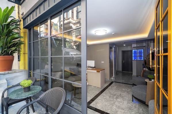 A modern hotel lobby with a glass partition, a reception desk, and seating areas. - Robin Hotel Istanbul (Istanbul)