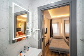 A modern hotel room with a marble bathroom, a bed, and a TV. - Robin Hotel Istanbul (Istanbul)