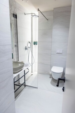 A modern bathroom with a glass-enclosed shower, a white sink, and a toilet. - Si Hotel Sh.p.k (Tirana)