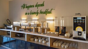 A breakfast bar with a coffee machine, various breakfast items, and a wall sign stating 'All happiness depends on a lovingly breakfast.' - Si Hotel Sh.p.k (Tirana)