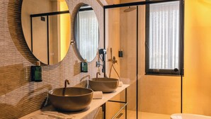 A modern bathroom with a large mirror, two sinks, a large bathtub, and a window with curtains. - Si Hotel Sh.p.k (Tirana)