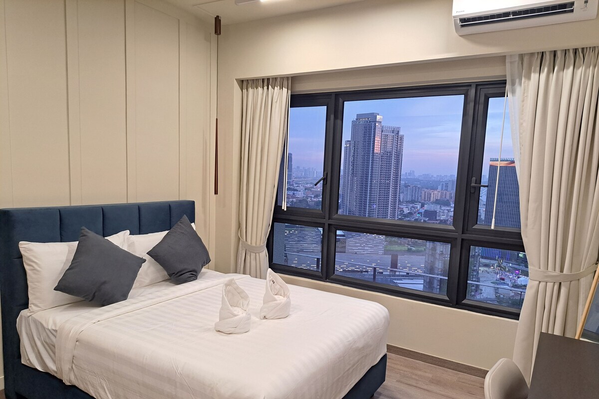 Ein Hotelzimmer mit einem großen Bett, einem Schreibtisch und einem Fenster mit Blick auf die Stadt.