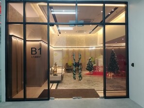 Eine Lobby mit Glastrennwand, einem Weihnachtsbaum und einem Schild mit der Aufschrift 'B1 Lobby'.