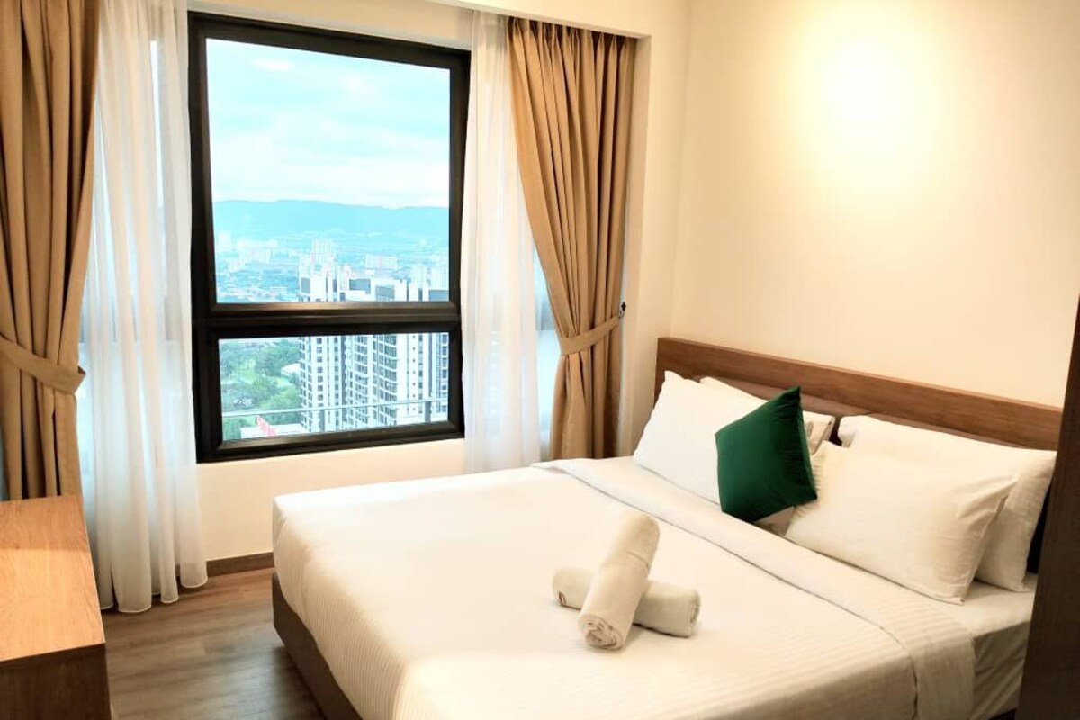 Ein Hotelzimmer mit Bett, Blick auf eine Stadtlandschaft durch ein Fenster und einem Holzkopfteil.