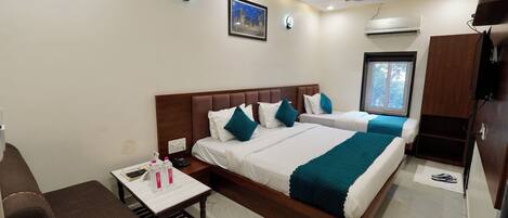A hotel room with a bed, bedside table, and a window.