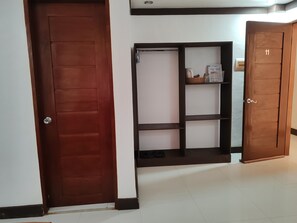 A hallway with a wooden door, a shoe rack, and a wardrobe with a number 11. - Jace's Travellers Inn By Zuzu (El Nido)