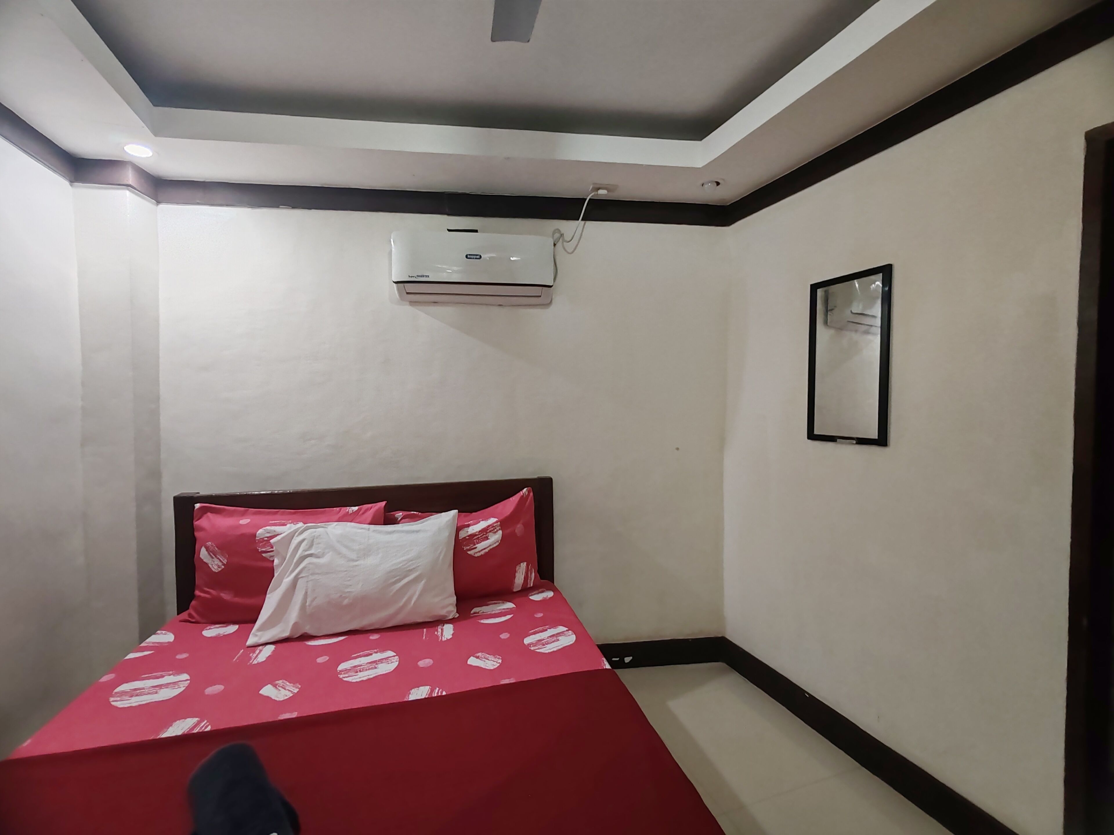 Une chambre à coucher avec un lit, un climatiseur et un tableau encadré au mur.