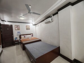 A bedroom with a bed, a ceiling fan, an air conditioning unit, and a door marked with the number 12. - Jace's Travellers Inn By Zuzu (El Nido)