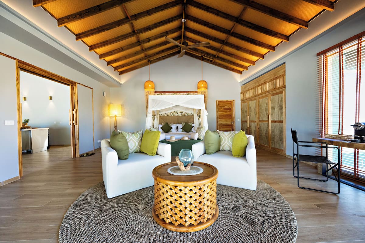 A living room with a white sofa, a wooden coffee table, and a ceiling fan.