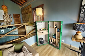 A cozy room with a green-framed open shelving unit containing various items, a wooden staircase, and a patterned wall hanging. - Bawe Island Resort (Bawe Island)