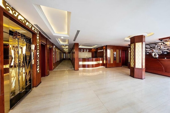 A hotel lobby with a reception desk, a long corridor, and a glass display case. - Towlan Qurtaba 1 (Riyadh)