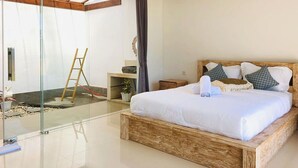 A modern bedroom with a glass door leading to a balcony, a wooden bed frame, and a small bedside table. - Volcano Side Kintamani Bali By Zuzu (Kintamani)