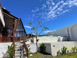 A building with a sloped roof, a staircase leading to a higher level, and a small tree in the foreground. - Volcano Side Kintamani Bali By Zuzu (Kintamani)