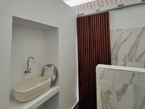 A bathroom with a marble sink, a shower curtain, and a marble wall. - Volcano Side Kintamani Bali By Zuzu (Kintamani)