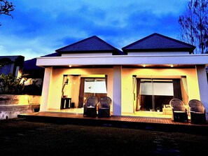 A modern two-story house with a flat roof, large windows, and a front porch with wicker chairs. - Volcano Side Kintamani Bali By Zuzu (Kintamani)