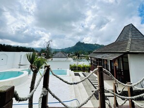 A resort with a pool, a wooden structure, and a view of mountains. - Volcano Side Kintamani Bali By Zuzu (Kintamani)