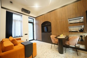 A modern living room with a sofa, a dining table with chairs, a TV, and built-in shelves. - Jais Home-moon Apartment-muzeului Square-old Town (Cluj-Napoca)