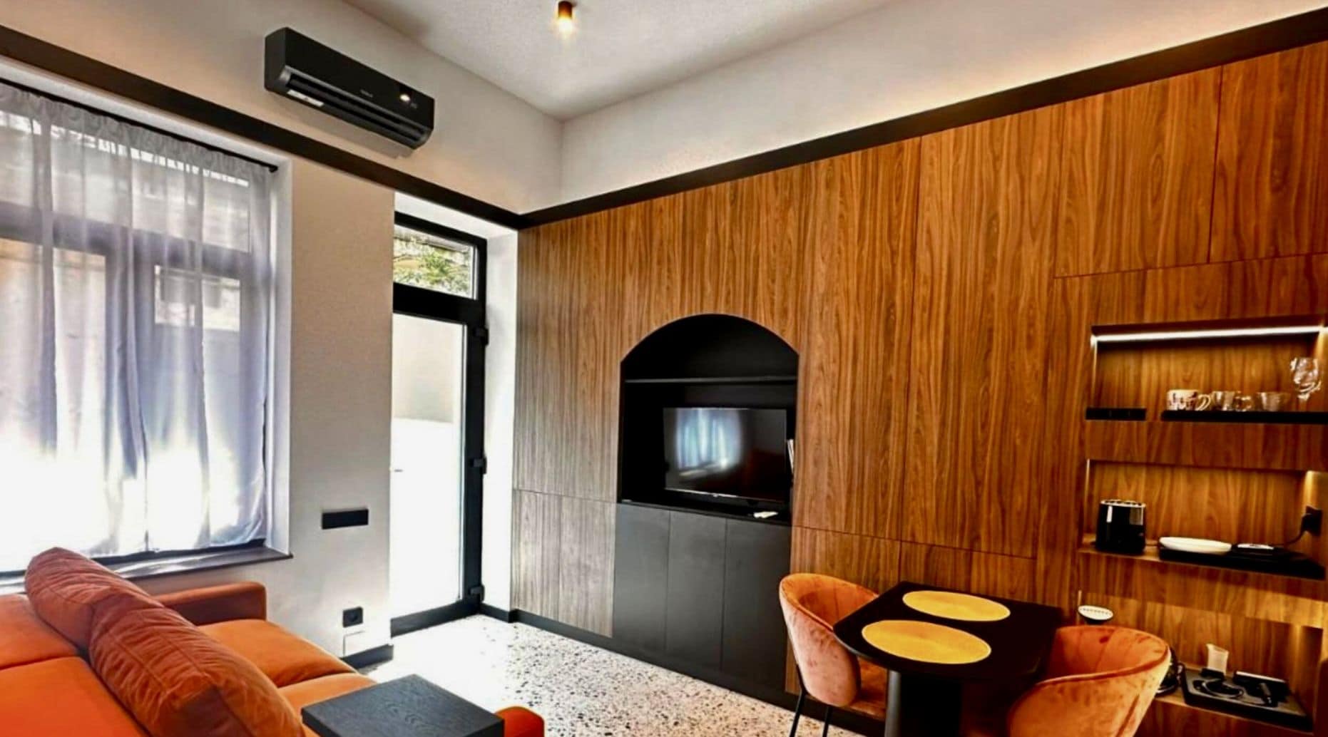 A modern living room with a sofa, a coffee table, and a TV.