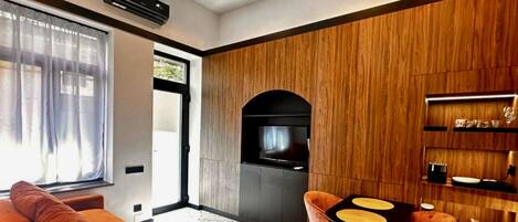 A modern living room with a sofa, a coffee table, and a TV.