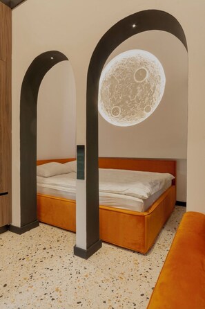 A bedroom with a bed, two archways, a circular moon-like ceiling decoration, and a speckled floor. - Jais Home-moon Apartment-muzeului Square-old Town (Cluj-Napoca)