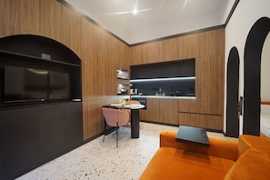A modern kitchen with wooden cabinetry, a built-in oven, and a dining area with a table and chairs. - Jais Home-moon Apartment-muzeului Square-old Town (Cluj-Napoca)
